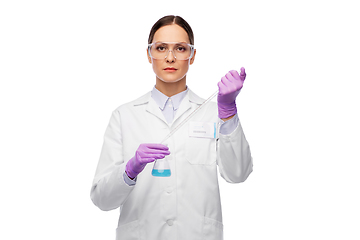 Image showing female scientist in goggles with chemical in flask