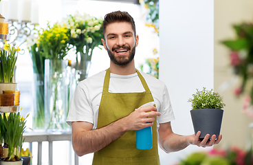 Image showing happy smiling male seller moisturizing flower