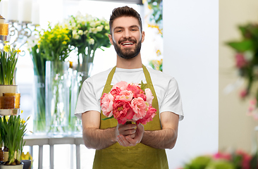 Image showing smiling male seller with bunch of peony flowers