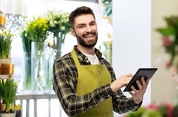 Image showing happy male seller with tablet pc at flower shop