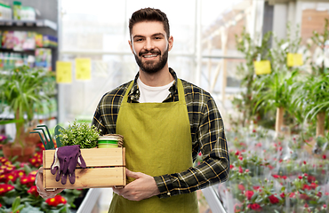 Image showing happy man with box of tools at garden center