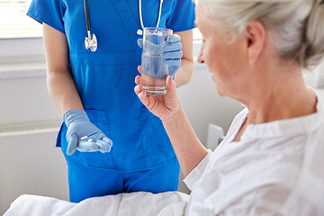 Image showing nurse giving medicine to senior woman at hospital