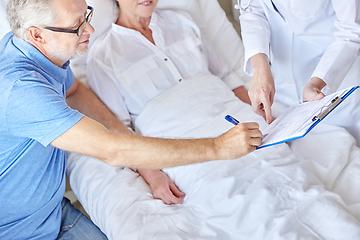 Image showing old couple and doctor with clipboard at hospital