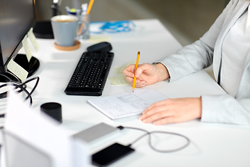 Image showing businesswoman with notebook and computer at office