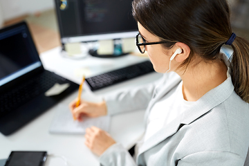 Image showing businesswoman with earphones working at office