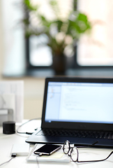 Image showing laptop, smartphone and notebook on table at office