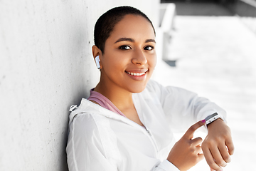 Image showing african woman with earphones and smart watch