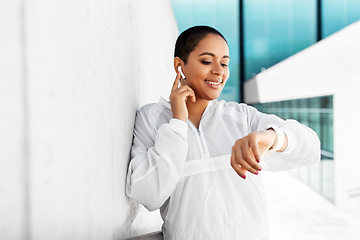 Image showing african woman with earphones and smart watch