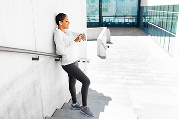 Image showing african woman with earphones and smart watch