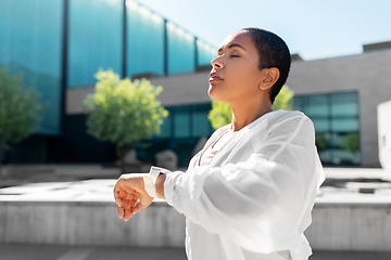 Image showing young woman with smart watch breathing outdoors