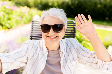 Image showing happy senior woman taking selfie at summer garden