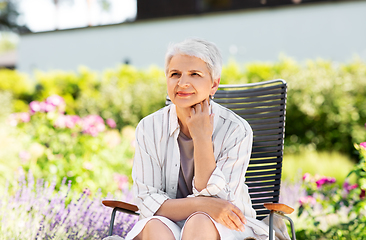 Image showing happy senior woman resting at summer garden