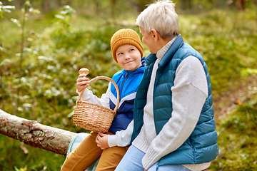 Image showing grandmother and grandson with mushrooms in forest