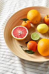 Image showing close up of citrus fruits on wooden plate