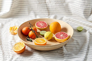 Image showing close up of citrus fruits on wooden plate