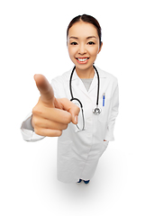 Image showing happy asian female doctor pointing to camera