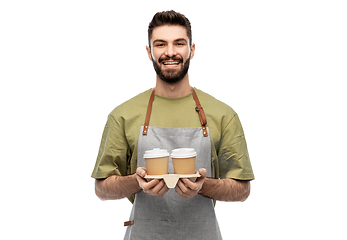 Image showing happy smiling barman in apron with takeaway coffee