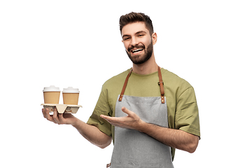 Image showing happy smiling barman in apron with takeaway coffee