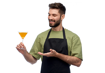 Image showing happy barman in apron with glass of cocktail