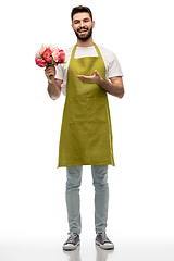 Image showing smiling male gardener with bunch of peony flowers