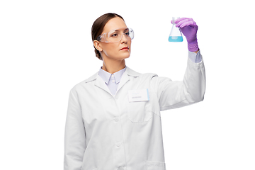 Image showing female scientist in goggles with chemical in flask