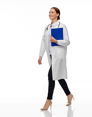 Image showing happy smiling female doctor walking with clipboard