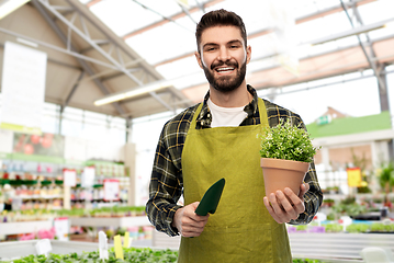 Image showing gardener or seller with trowel at flower shop