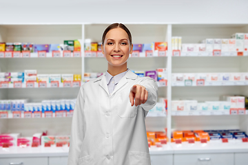 Image showing female pharmacist pointing to camera at pharmacy