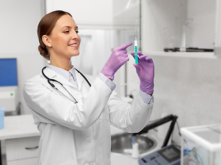 Image showing happy female doctor with syringe at hospital