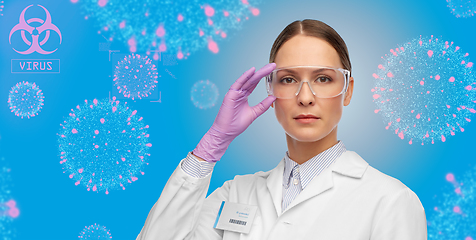 Image showing female scientist in goggles and gloves over virus