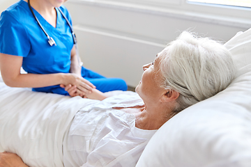 Image showing doctor or nurse visiting senior woman at hospital