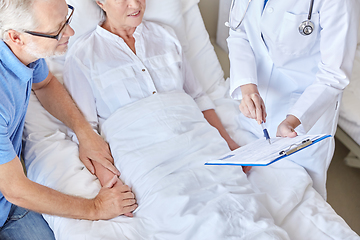 Image showing old couple and doctor with clipboard at hospital