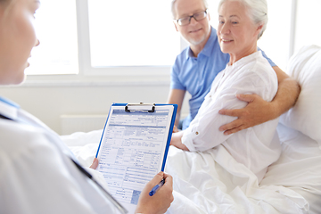 Image showing old couple and doctor with clipboard at hospital