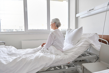 Image showing lonely senior woman sitting in bed at hospital