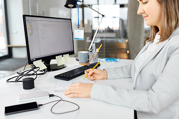 Image showing businesswoman with notebook and computer at office