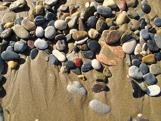 Image showing Wet sea pebbles on the sand