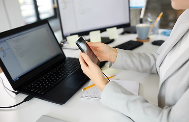 Image showing businesswoman with smartphone working at office