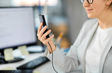 Image showing businesswoman with smartphone working at office