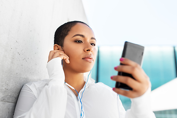 Image showing african american woman with earphones and phone