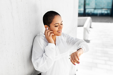 Image showing african woman with earphones and smart watch