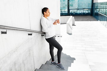 Image showing african woman with earphones and smart watch