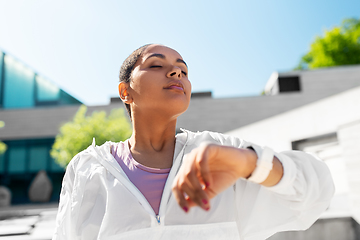 Image showing young woman with smart watch breathing outdoors