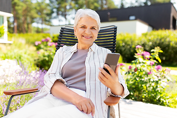 Image showing happy senior woman with phone at summer garden