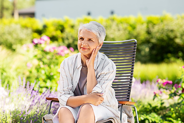 Image showing happy senior woman resting at summer garden