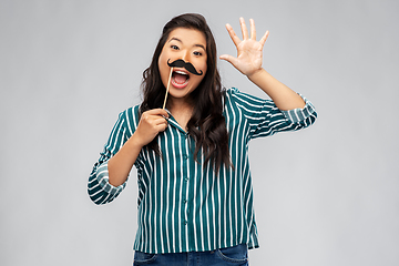 Image showing asian woman with vintage moustaches party prop