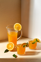 Image showing glasses with orange juice and peppermint on table