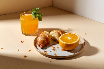 Image showing glass of orange juice and croissant on plate