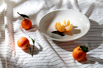 Image showing still life with mandarins on plate over drapery