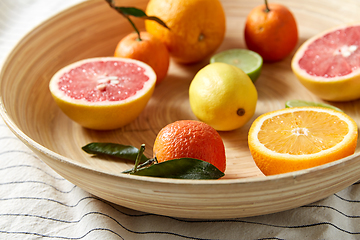 Image showing close up of citrus fruits on wooden plate