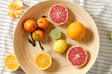 Image showing close up of citrus fruits on wooden plate